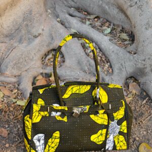 Bolso con estampado africano en tonos amarillos y verdes artesanal, símbolo de moda inclusiva y consciente.​