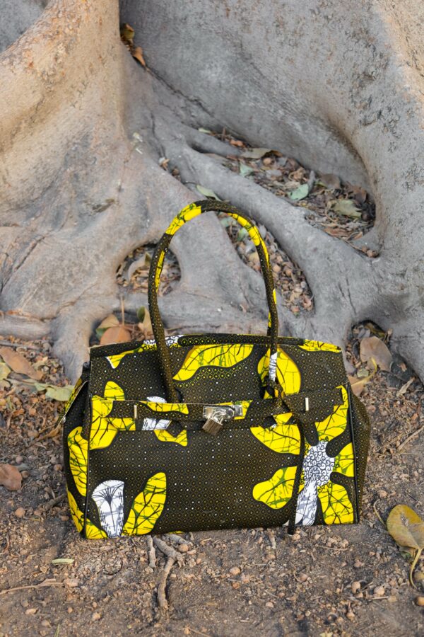 Bolso con estampado africano en tonos amarillos y verdes artesanal, símbolo de moda inclusiva y consciente.​