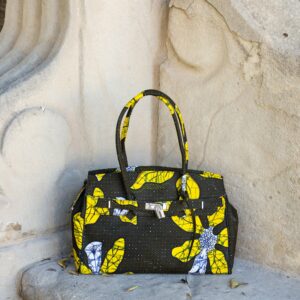 Bolso con estampado africano en tonos amarillos y verdes artesanal, símbolo de moda inclusiva y consciente.​