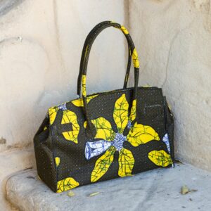 Bolso con estampado africano en tonos amarillos y verdes artesanal, símbolo de moda inclusiva y consciente.​