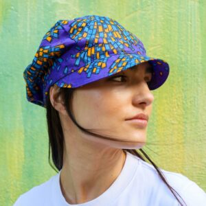 Gorra con estampado africano en tonos morado, azul y amarillo. Tejida a mano. Moda ética, única y con estilo.