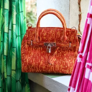 Bolso en tonos naranja con estampado africano. Hecho a mano y diseño exclusivo. Moda solidaria y con historia.