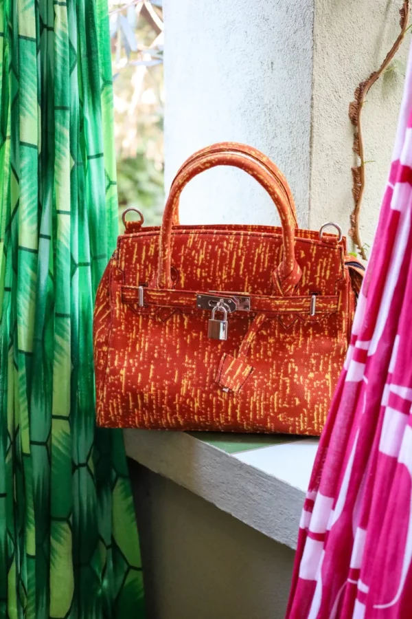 Bolso en tonos naranja con estampado africano. Hecho a mano y diseño exclusivo. Moda solidaria y con historia.